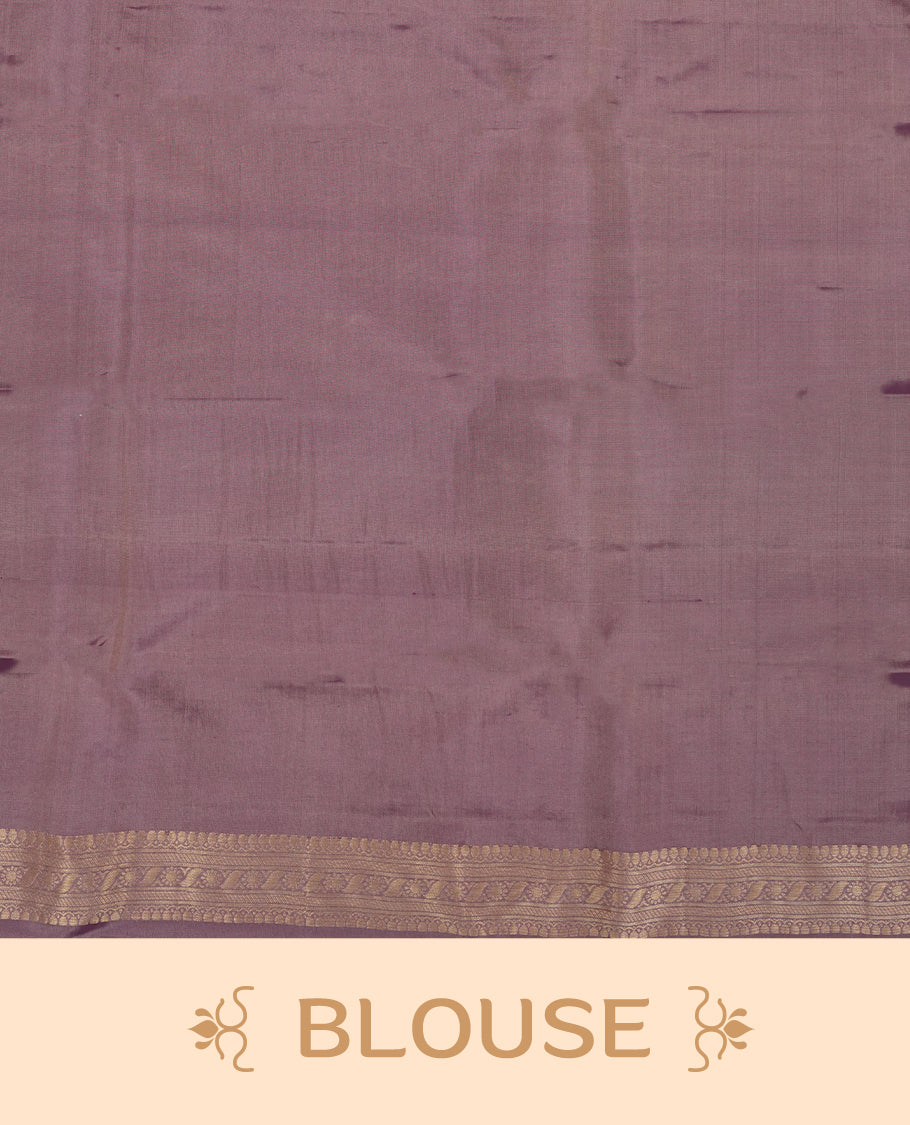 Dusty purple colour Vasundhara silk saree featuring self colour zari motifs across the body, finished with a self‑coloured traditional border with kathir motifs and a coordinating blouse.