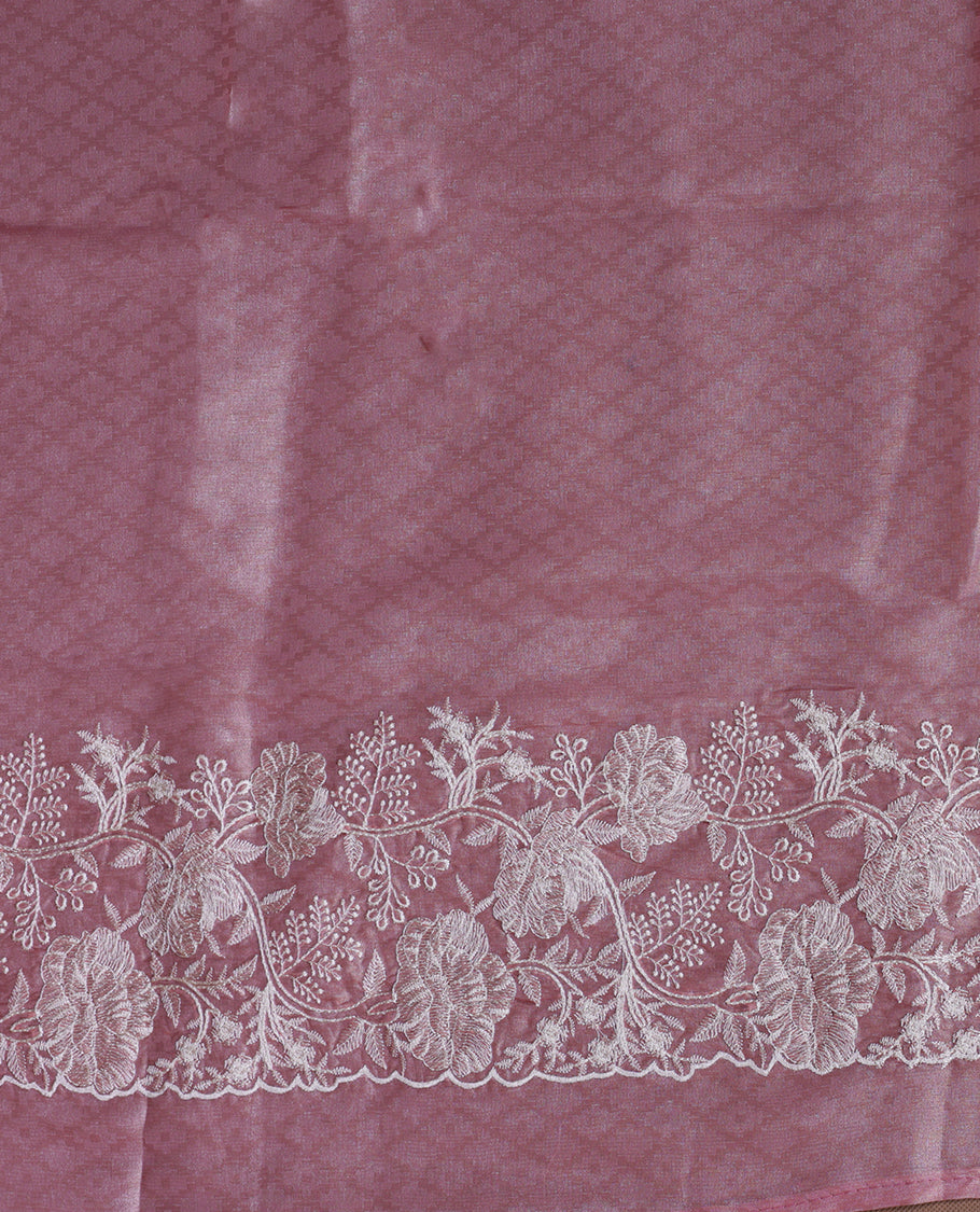 Pink colour organza designer saree featuring a subtle self patterned body and an intricately scalloped floral thread embroidered border all around, complemented by a coordinating embroidered pallu and paired with a matching blouse.