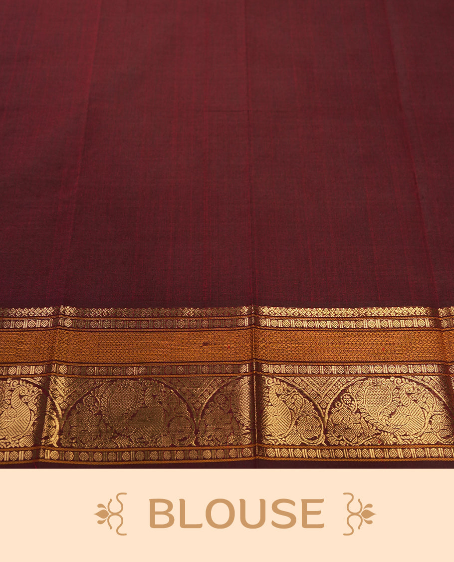 Maroon colour Pure Kanchi cotton saree adorned with subtle golden buttas all over, highlighted by a rich zari woven border with traditional motifs & Includes a matching blouse piece for a complete look.