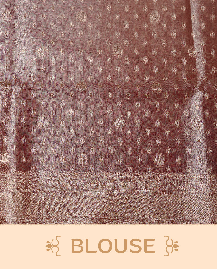 Pastel peach colour semi tissue silk saree featuring floral zari motifs on body, complemented by gold zari traditional border, paired with matching blouse piece.