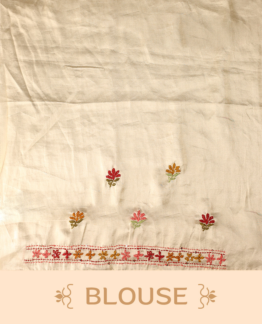 Cream colour pure tussar saree adorned with delicate pink and green floral embroidery along the border and scattered motifs across the body, paired with a matching blouse.