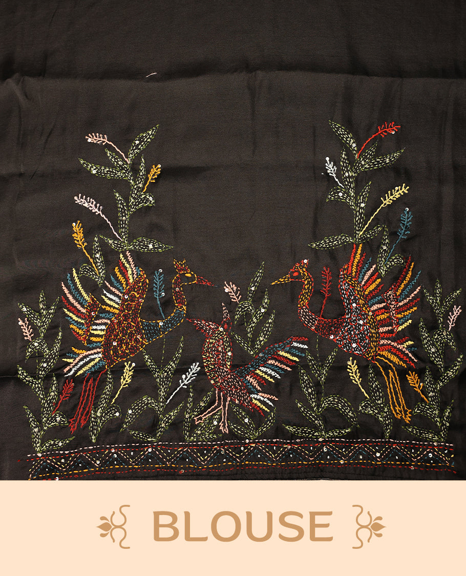 Black colour pure tussar saree adorned with delicate multicolour floral embroidery along the border and scattered motifs across the body, paired with a matching blouse.