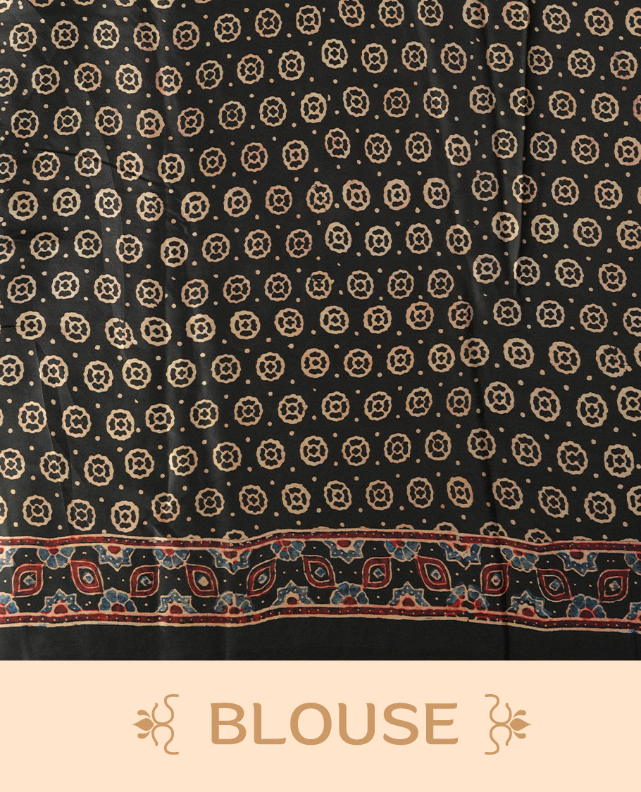 Black colour saree featuring intricate traditional prints in earthy tones, finished with a sleek satin border and tassel details & Comes with a stylish matching blouse.