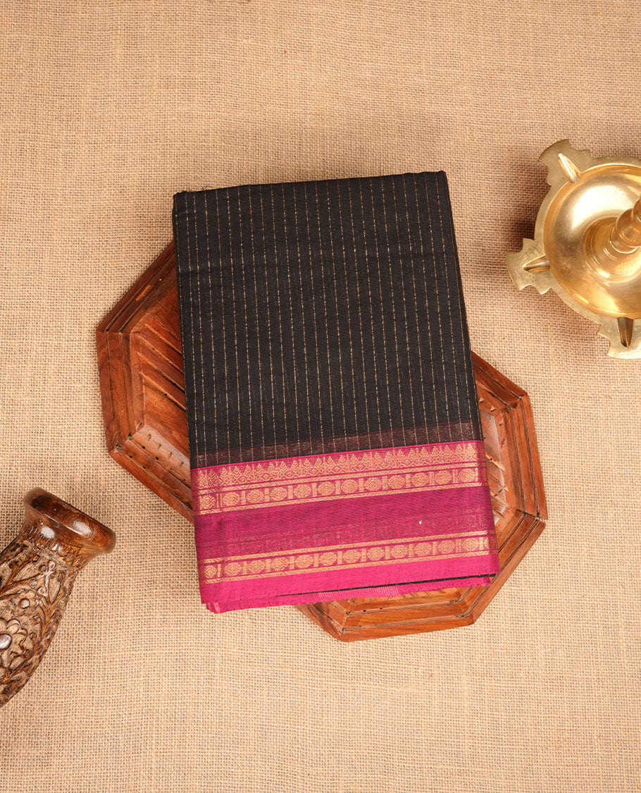 Black colour chettinad cotton featuring gold zari check pattern on body , complemented by contrast teal & magenta double colour with gold zari border, paired with matching blouse piece.