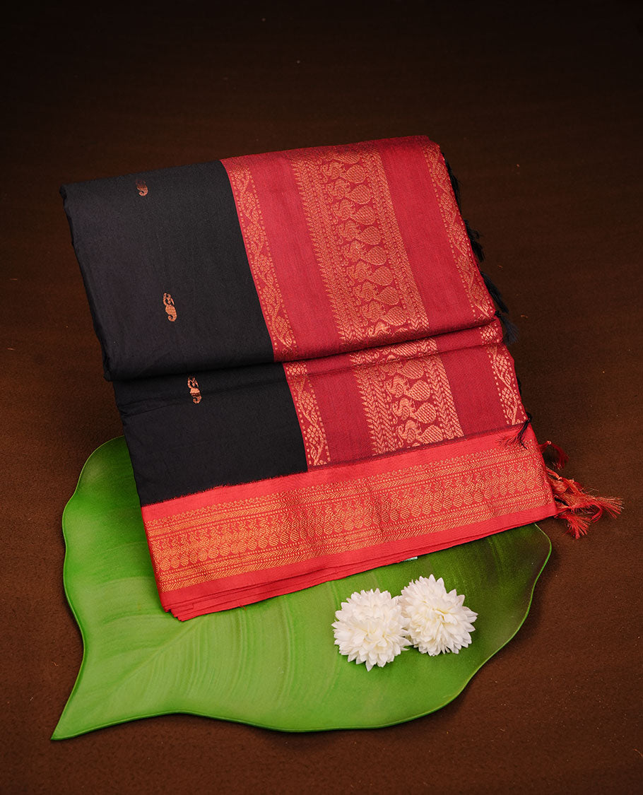 Black colour kalyani cotton saree featuring antique zari motifs on body, complemented by red colour with Antique zari border, paired with matching blouse piece.