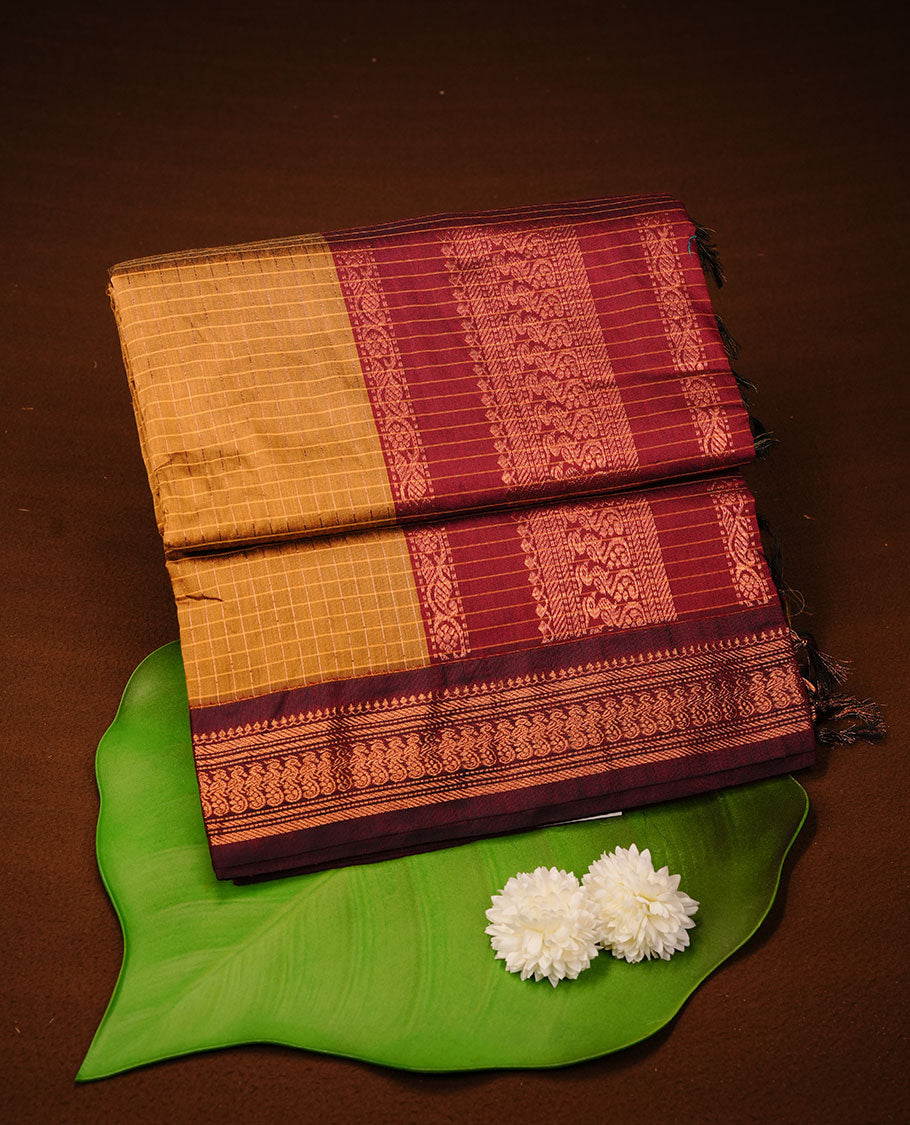 Mustard colour kalyani cotton saree featuring gold zari check pattern on body, complemented by Maroon colour with Antique zari border, paired with matching blouse piece.