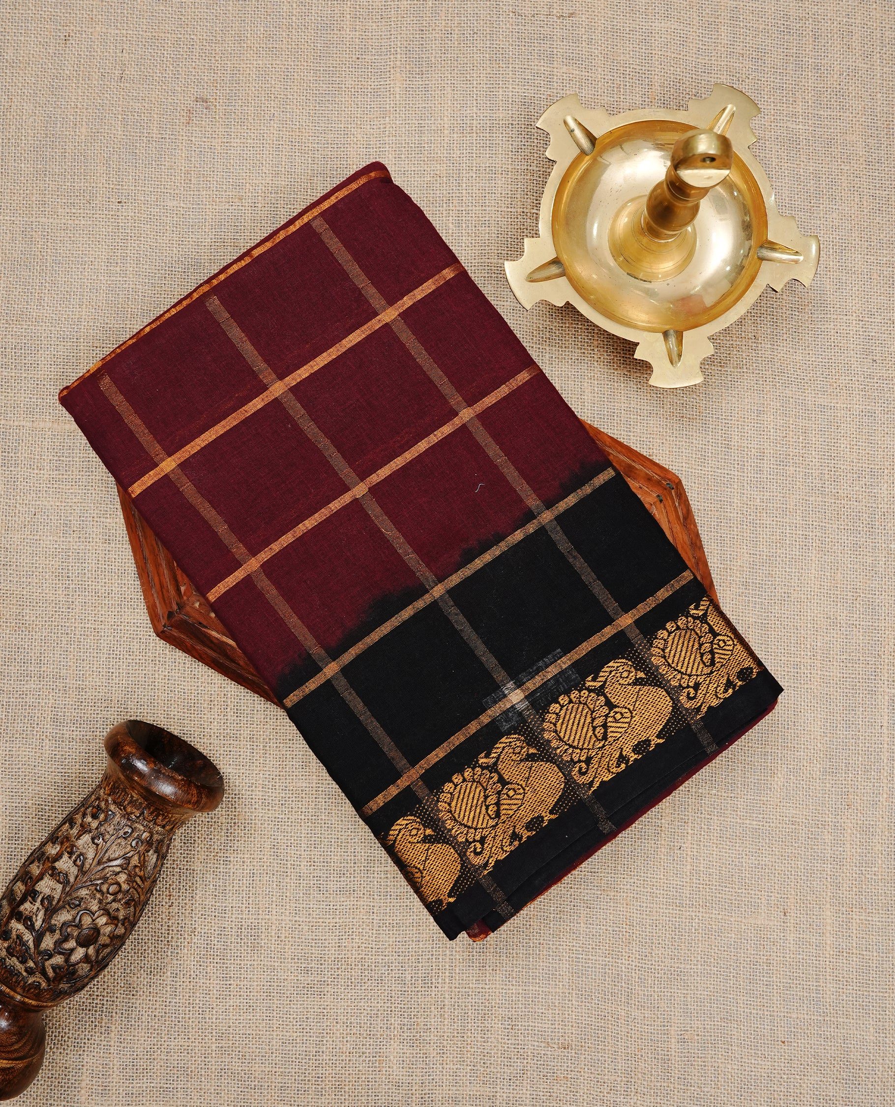 Maroon colour Sungudi cotton saree featuring Gold zari Check pattern on body, Gold zari Peacock design on Dyed Black colour design border, paired with matching blouse piece.