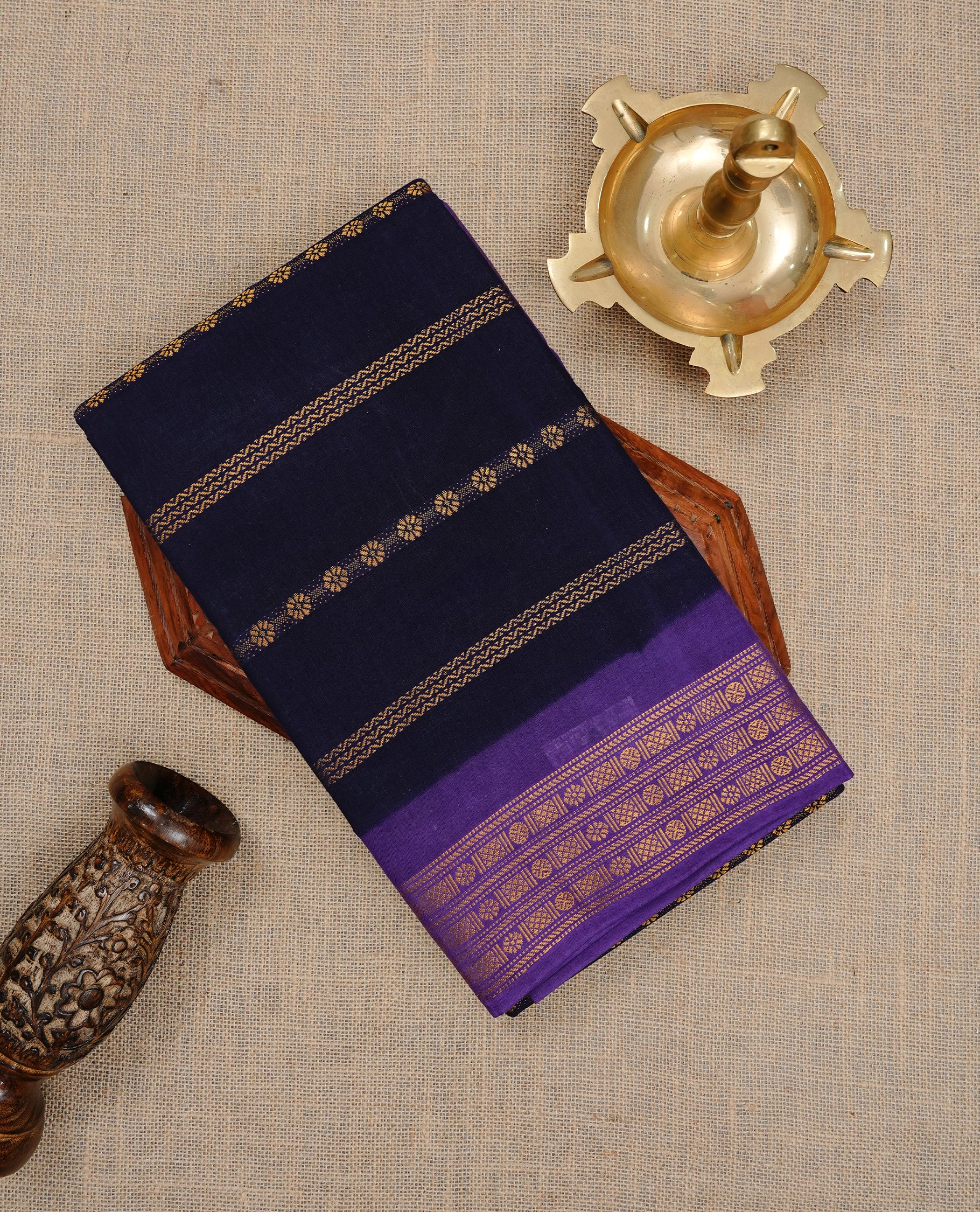Navy Blue colour Sungudi cotton saree featuring Gold zari Stripes on body, Gold zari on Contrast Purple colour border, paired with matching blouse piece.