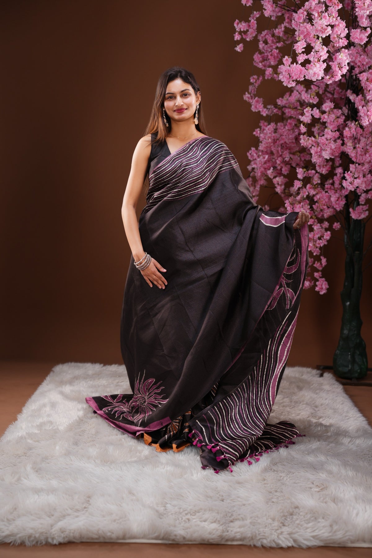 Black colour Semi Khadi Silk Saree featuring a plain black body, complemented by a purple colour geometric pattern on border and paired with a matching blouse piece.