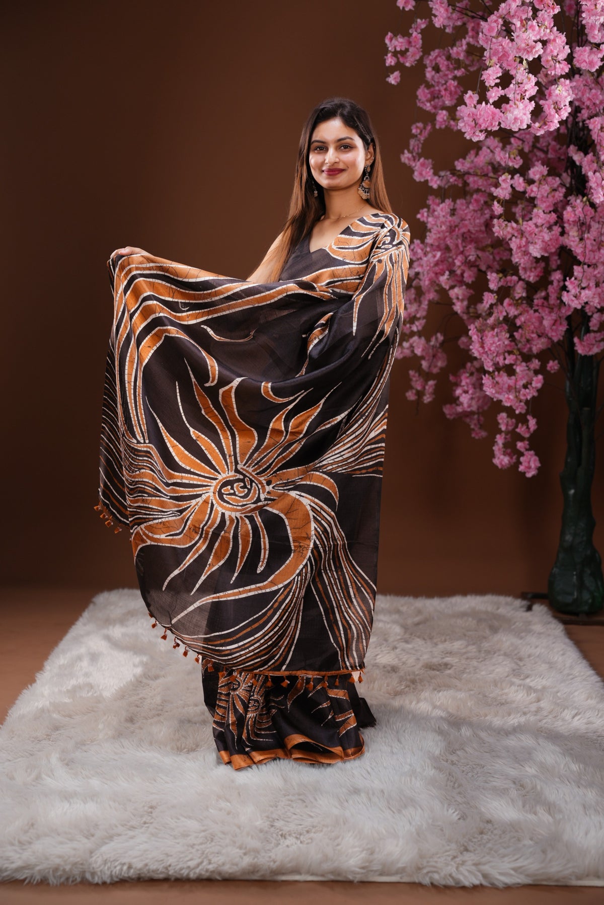 Black colour Semi Khadi Silk Saree featuring a plain black body, complemented by a rust orange colour geometric pattern on border and paired with a matching blouse piece.