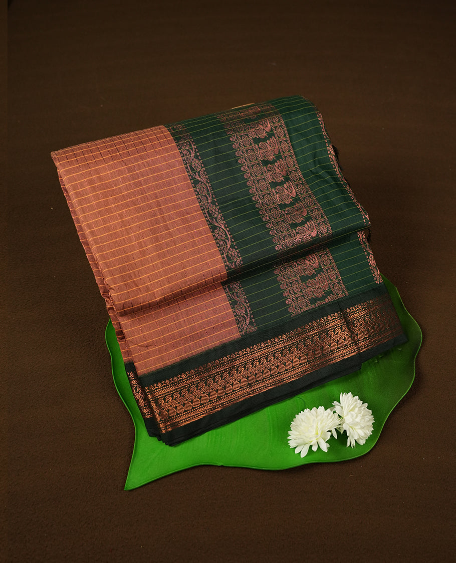 copper coloured mixed Kalyani cotton saree featuring copper zari checks on the body, complemented by a dark green coloured border and pallu adorned with copper zari patterns, Paired with a matching blouse.
