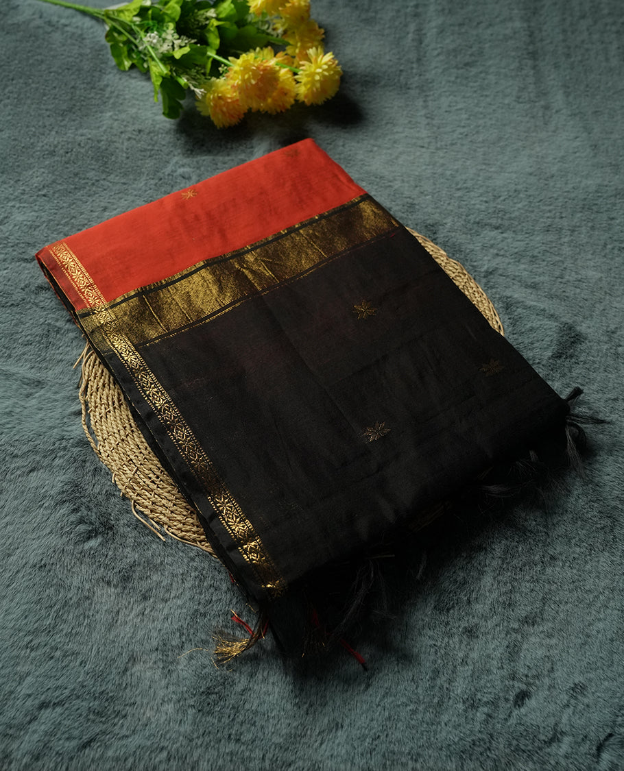 Black colour Silk Cotton Saree with Contrasting Rust Red Top Border, Antique Gold Zari Temple Border and Butta Motifs, Finished with Tassel Detailing and a Coordinated Matching Blouse Piece