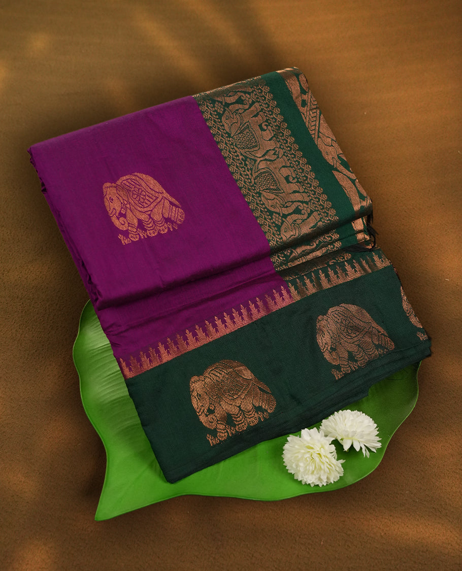 Purple colour Kalayani cotton saree featuring majestic copper zari elephant motifs on the body, paired with a contrasting green border and pallu adorned in intricate traditional designs with matching blouse