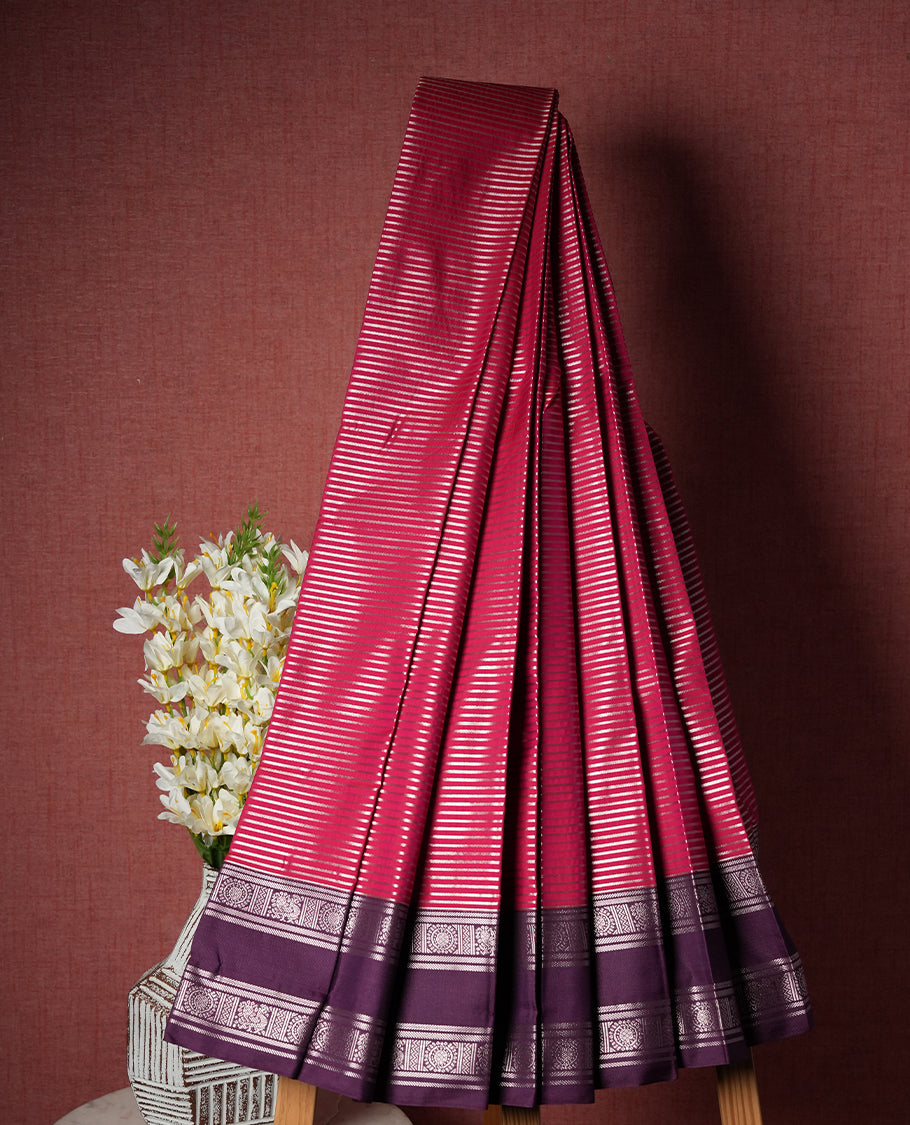 Rani pink colour Semi Silk Saree with silver zari patterns on the body, paired with a contrasting dark purple colour traditional pallu and border, and a matching blouse piece.