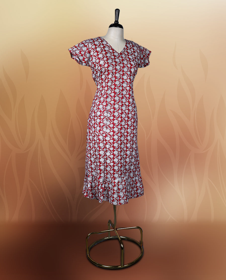 Red colour nightwear with a charming white floral print, featuring a V neckline, flutter sleeves, and a flared ruffle hem, A perfect pick for casual days, summer outings, or light festive wear.