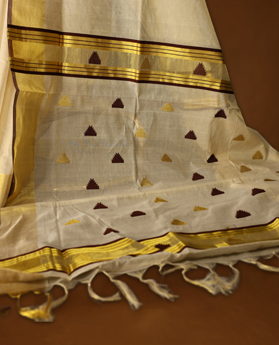 Elegant pure handloom soft tissue kerala saree adorned with small golden and brown triangle motifs, featuring a shimmering golden zari border and pallu, and paired with matching blouse, perfect for festivities.