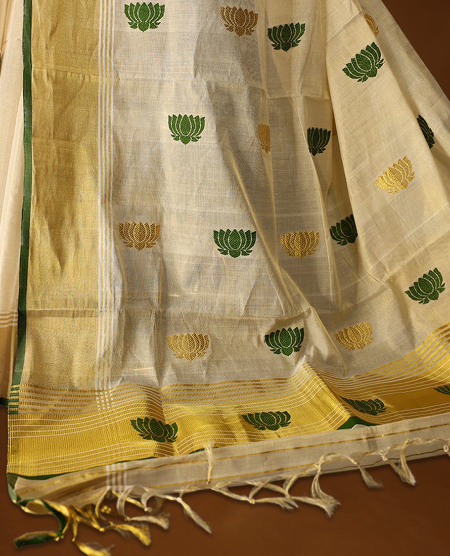 Elegant handloom soft tissue Kerala saree,Featuring a cream base with gold zari, green borders & lotus motifs, and paired with a matching blouse, perfect for festive and traditional occasions.