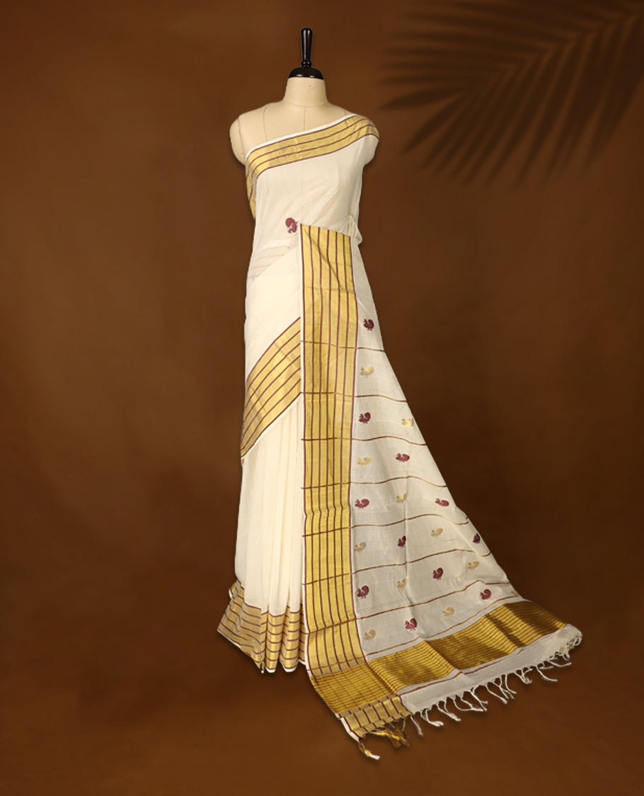 Elegant pure handloom cotton Kerala saree with a cream base, gold zari stripes, maroon & gold floral motifs. Paired with a matching blouse, it’s perfect for festive celebrations and traditional occasions.