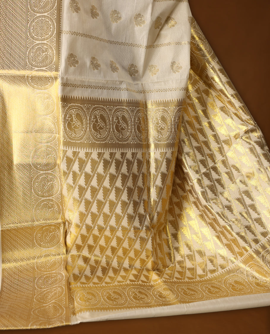 Elegant cotton Kerala saree in cream, adorned with rich gold zari work and traditional floral motifs.,The intricate pallu and broad border add elegance, Paired with a matching blouse, ideal for festive occasions.