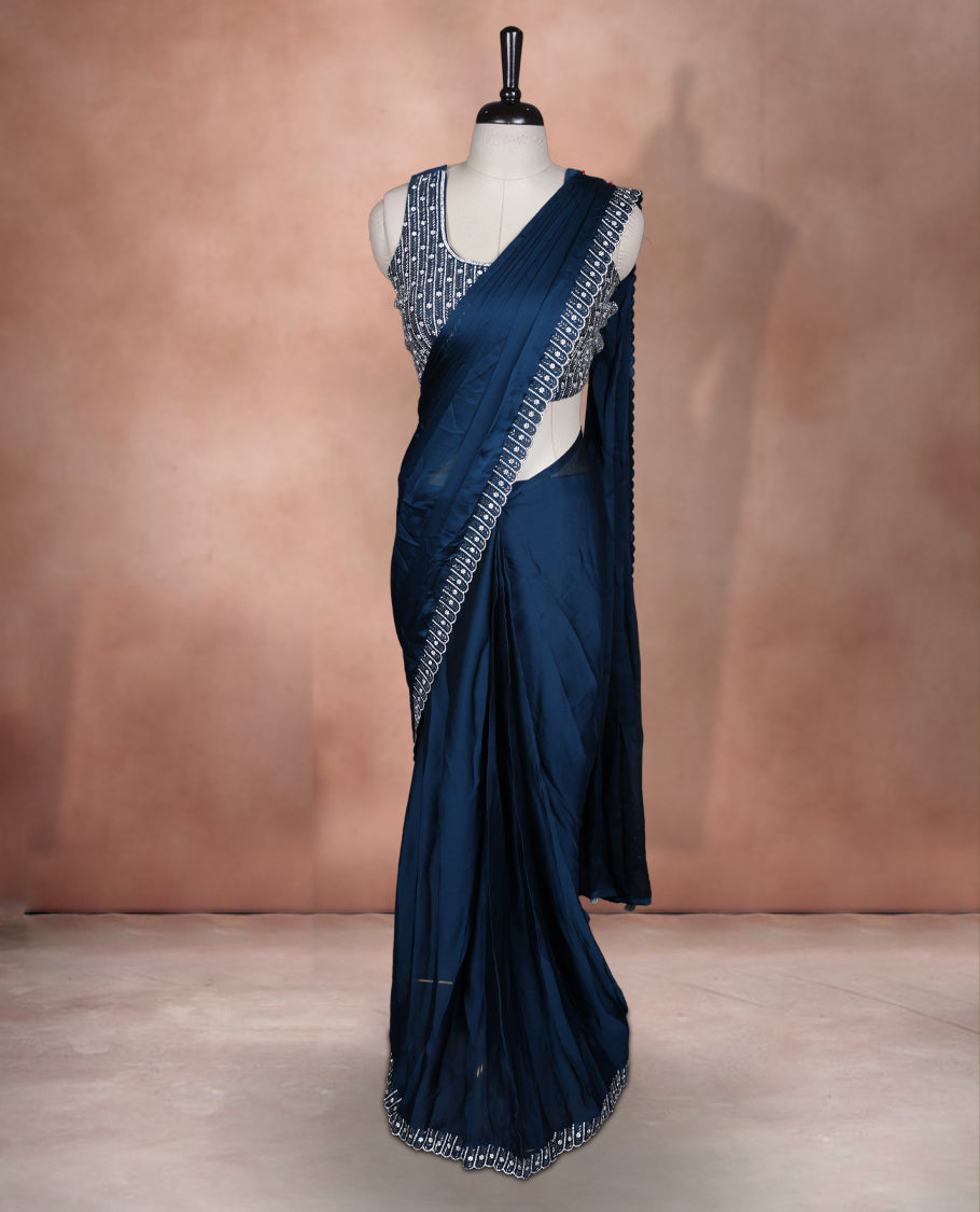 Elegant Teal colour ready to wear saree adorned with rich silver Stone and bead embroidery along the border and pallu, paired with a heavily embellished matching blouse for a grand festive look.