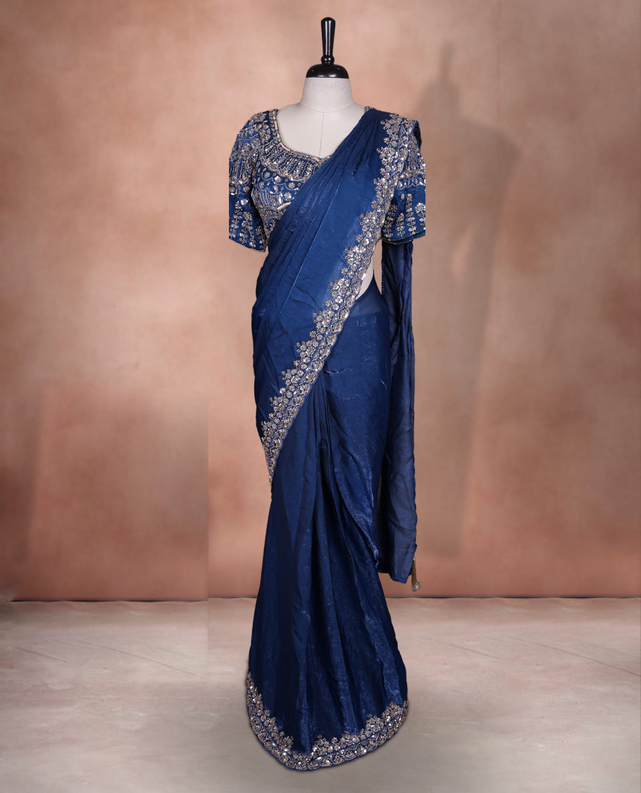 Elegant Dark teal colour ready to wear saree adorned with rich silver bead embroidery along the border and pallu, paired with a heavily embellished matching blouse for a grand festive look.