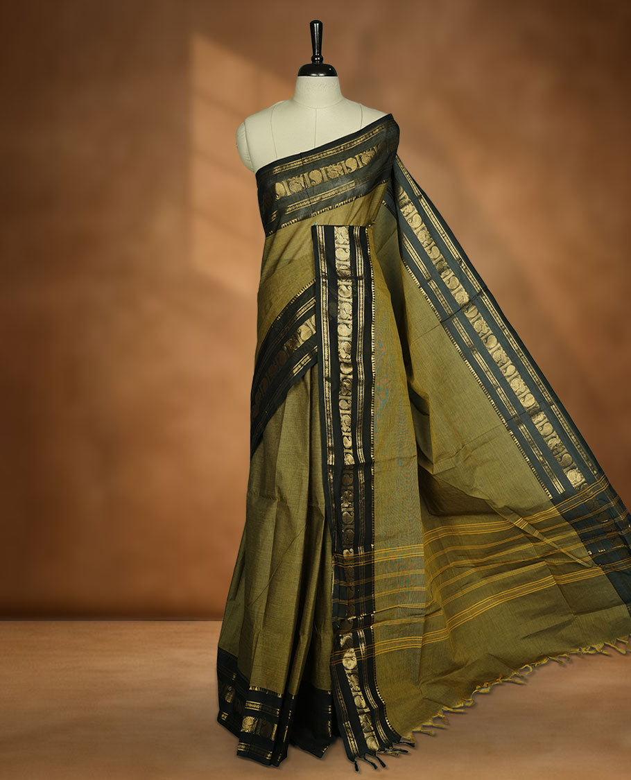 Mehandi colour chettinad cotton saree featuring plain body, contrast black colour with traditional gold zari border paired with matching blouse.
