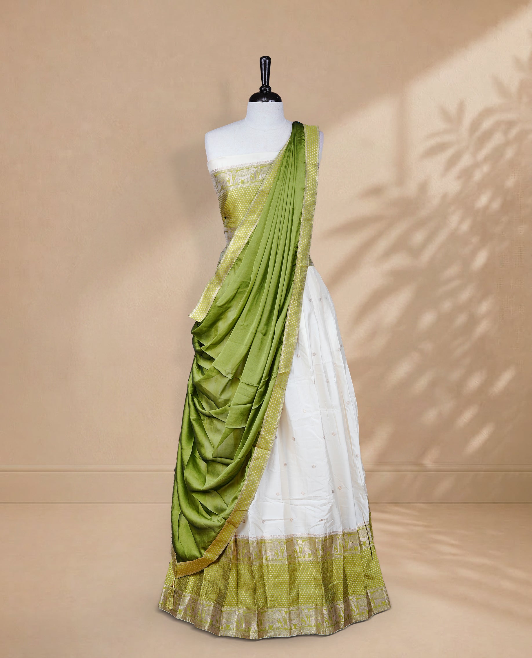 Cream colour Half saree featuring Gold zari buttas on skirt with Zari border on contrast Green colour border, Unstitched Blouse and matching dupatta.