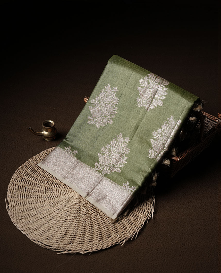 Olive green colour pure banaras tusser silk saree highlighting antique zari pattern across body, with contrast cream colour with zari border and paired with matching blouse