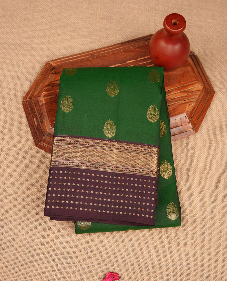 Green colour Vasundhara silk saree featuring gold zari buttas on body, complemented by contrast burgundy colour zari border, paired with matching blouse piece.
