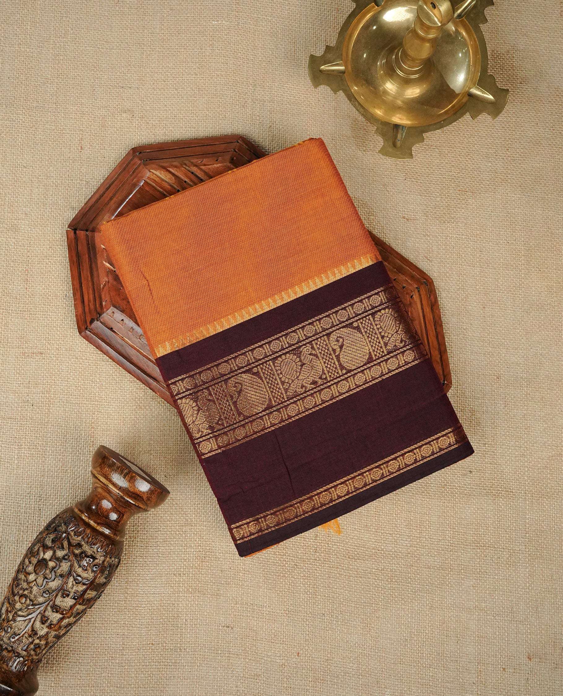 Mustard Orange colour chettinad cotton saree featuring elegant plain body, Contrast Chocolate colour with Gold zari border, comes with matching blouse piece.