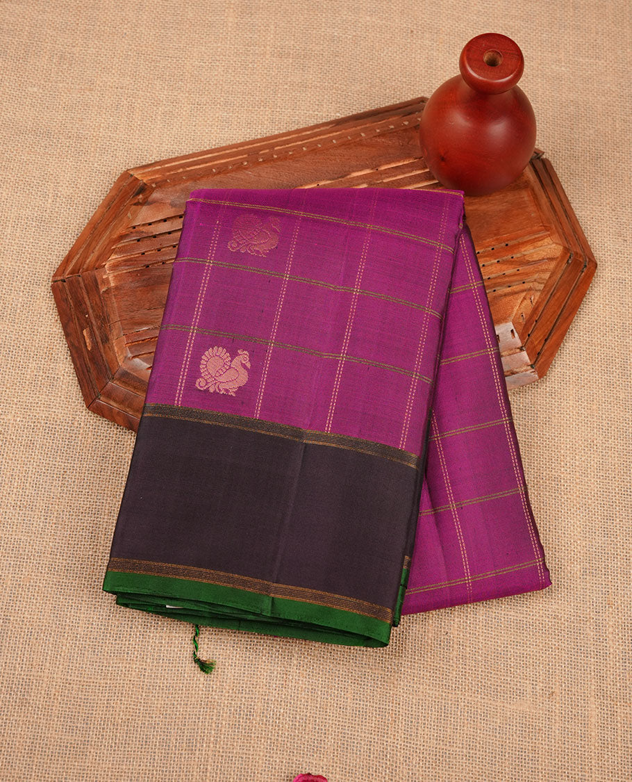 Burgundy colour soft silk saree featuring elegant gold zari check across the body, complemented by a contrast deep purple with green piping on border, and paired with a matching blouse piece.
