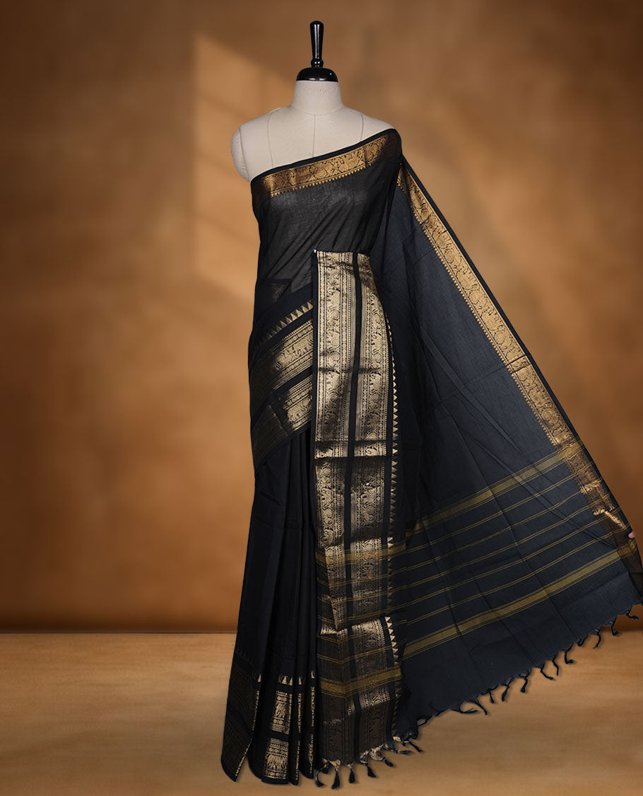 Black colour chettinad cotton saree featuring plain body, self colour with traditional gold zari border paired with matching blouse.
