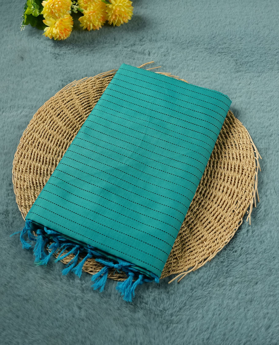 Teal blue colour poly cotton saree with black vertical dotted line pattern on the body, paired with a matching pallu featuring black zigzag geometric border, and a coordinated all‑over black stylised fleur‑de‑lis printed blouse piece.