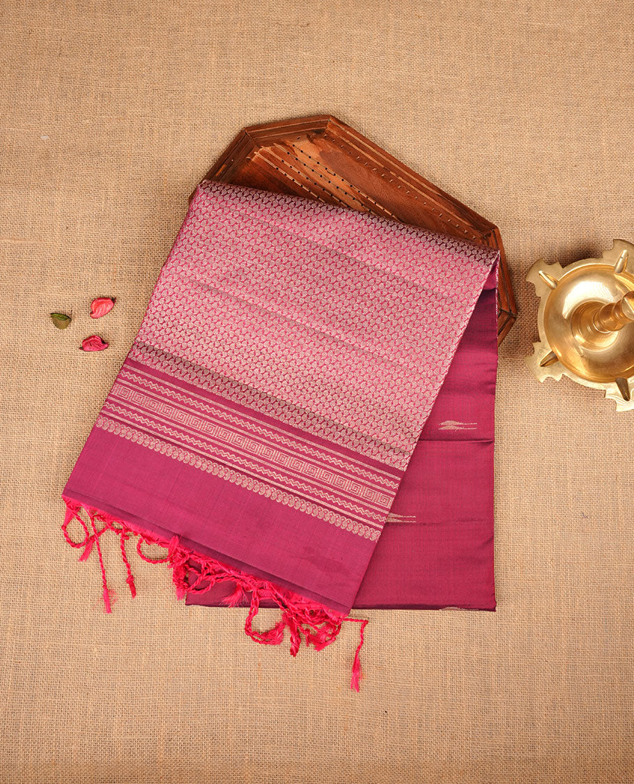 Burgundy colour soft silk saree featuring gold zari motifs on body, complemented by self colour with traditional border with tassel at pallu, paired with matching blouse piece.