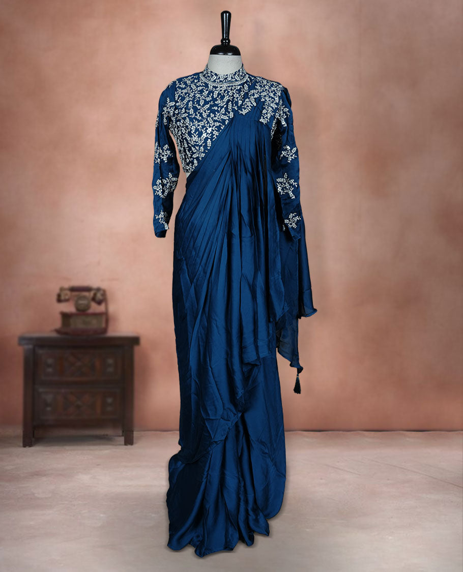 Deep teal colour ready to wear saree Fearturing intricate silver embroidery on the pallu, paired with a beats and thread embroidered matching blouse.