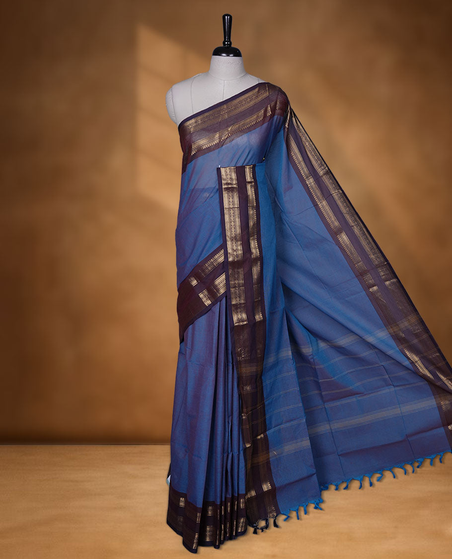 Blue colour chettinad cotton saree featuring Elegant body, contrast purple colour border with gold zari border, pallu and paired with matching blouse.