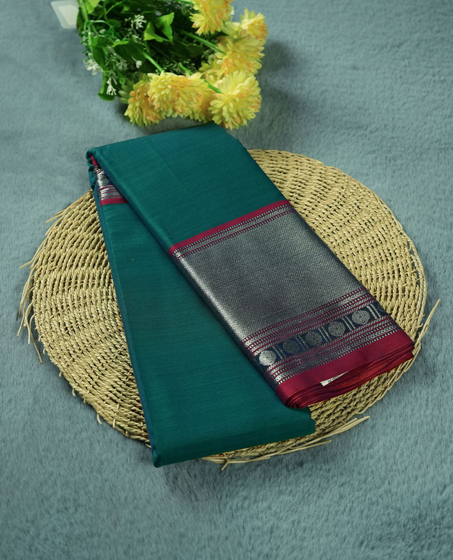 Peacock colour Narayanapattu cotton saree featuring a self coloured body, contrast deep red colour with silver zari border and pallu, pairing a matching blouse piece.