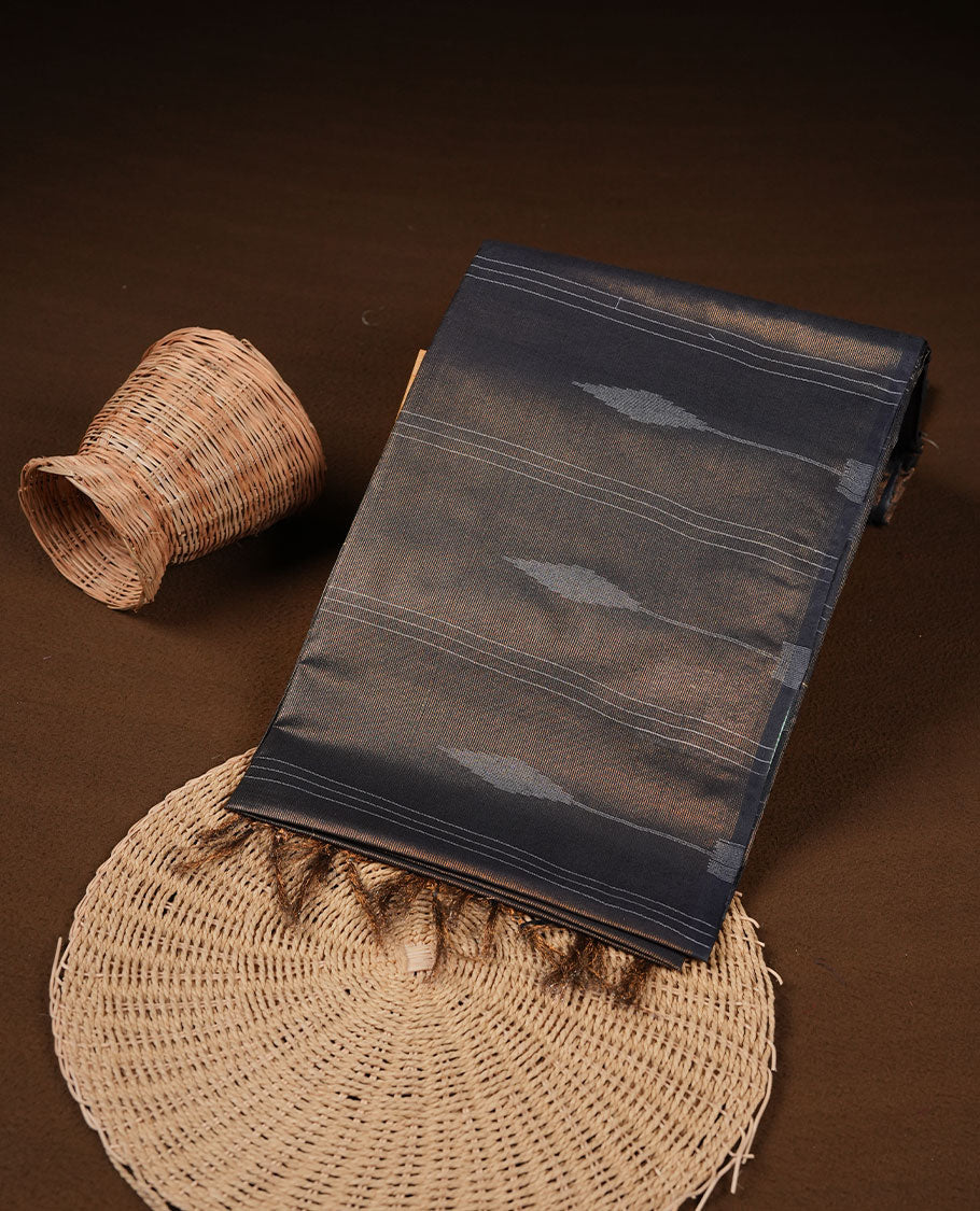 Black colour semi jute saree highlighting gold zari stripped body with white motifs, without border and paired with matching blouse.