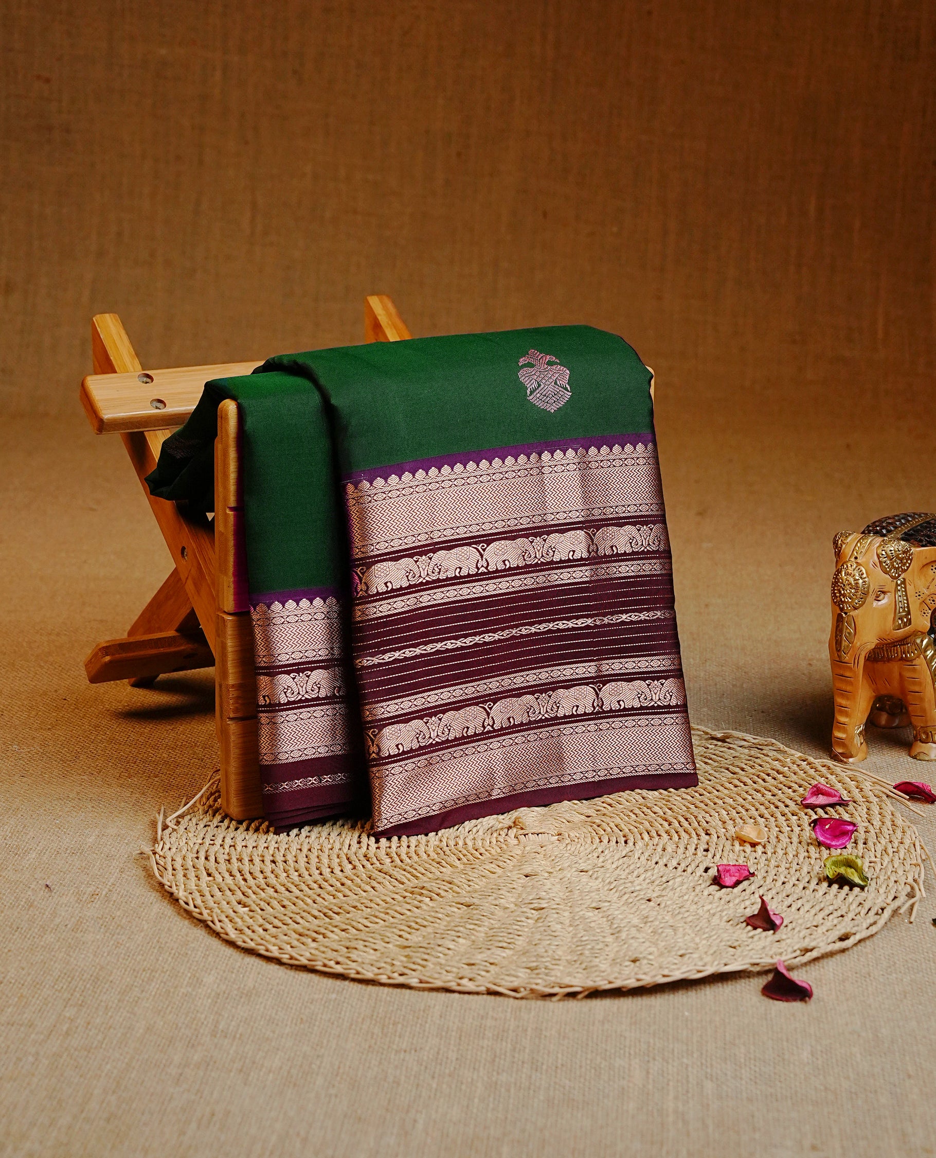 Bottle Green Colour Kancheepuram silk saree featuring gold zari motifs on body, highlighting Gold zari Elephant Traditional On contrast Maroon border, paired with Matching blouse piece.