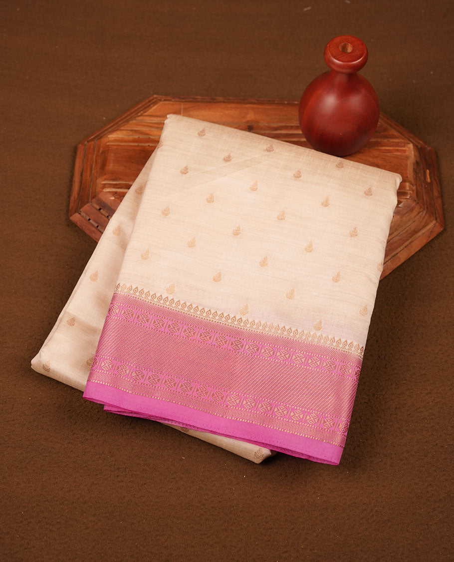 White gold colour semi tussar saree featuring Gold zari buttas body, contrast Pink colour gold zari border and comes with matching blouse piece.