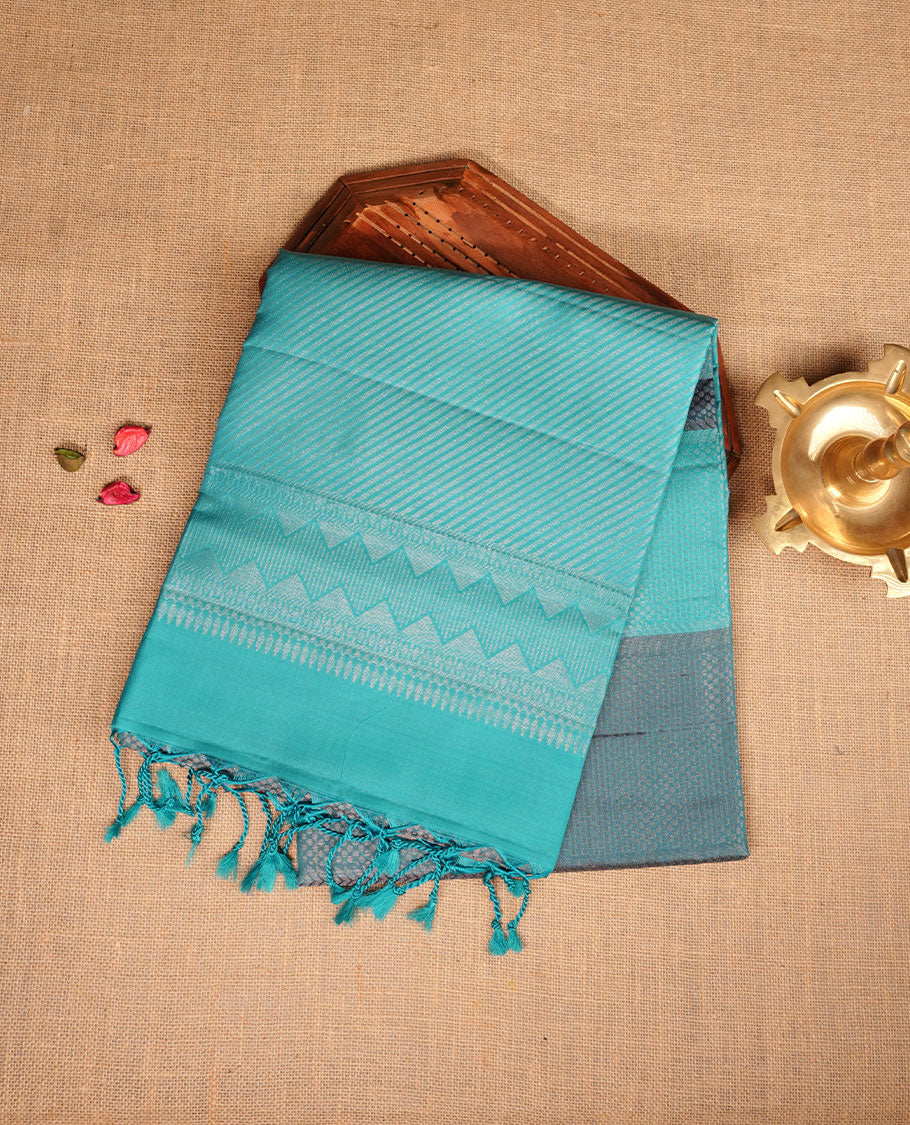 Aqua & teal colour soft silk saree featuring gold zari motifs on body, complemented by self colour with traditional border with tassel at pallu, paired with matching blouse piece.
