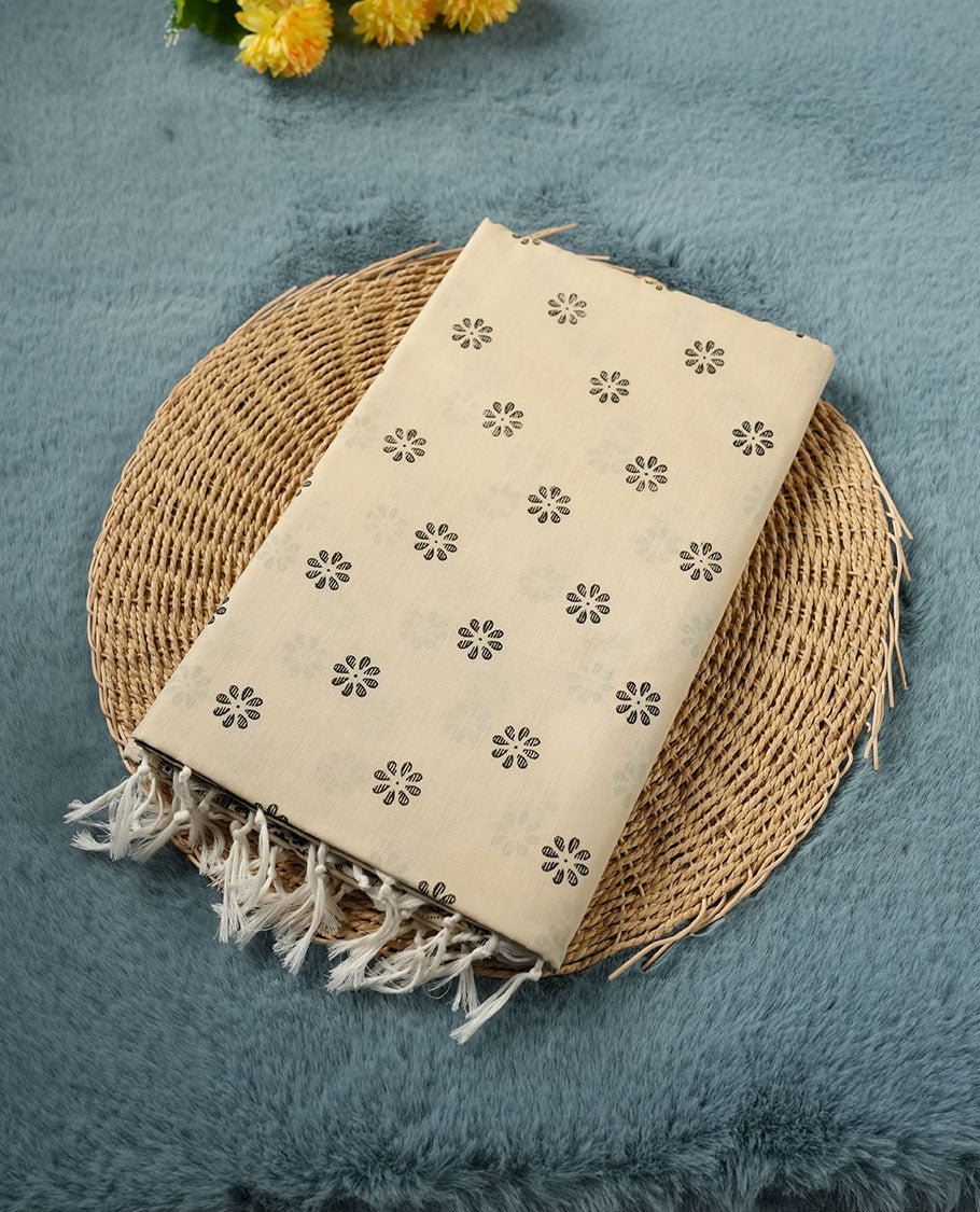 Cream colour poly cotton saree with black floral butti motifs on the body, paired with a matching pallu featuring black ornate floral jaal and stripes on the border, and a coordinated all‑over black paisley printed blouse piece.