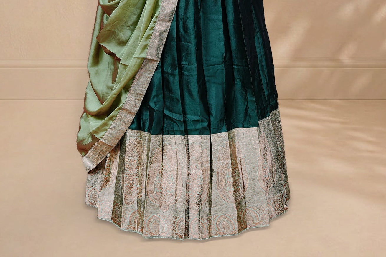 Green colour Half saree featuring Plain skirt with Zari border on contrast Light green colour border, Unstitched Blouse and matching dupatta.