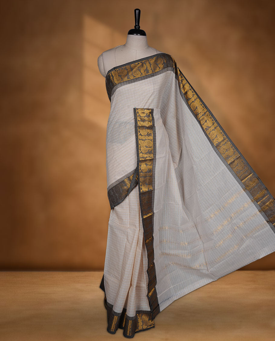 Beige colour chettinad cotton saree featuring gold zari check patterned body, paired with a grey colour traditional gold zari border without blouse.