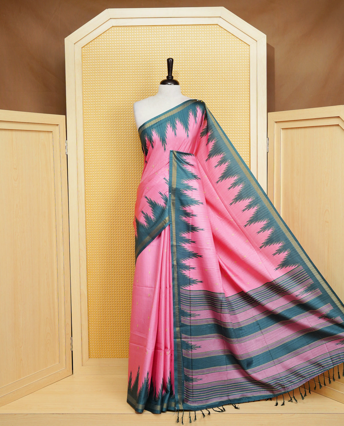 Pink and Dark Green Colour Kattan silk saree featuring buttas all over the body, a temple-designed border & a contrasting striped pallu with tassels. Paired with a matching contrast-striped blouse piece.