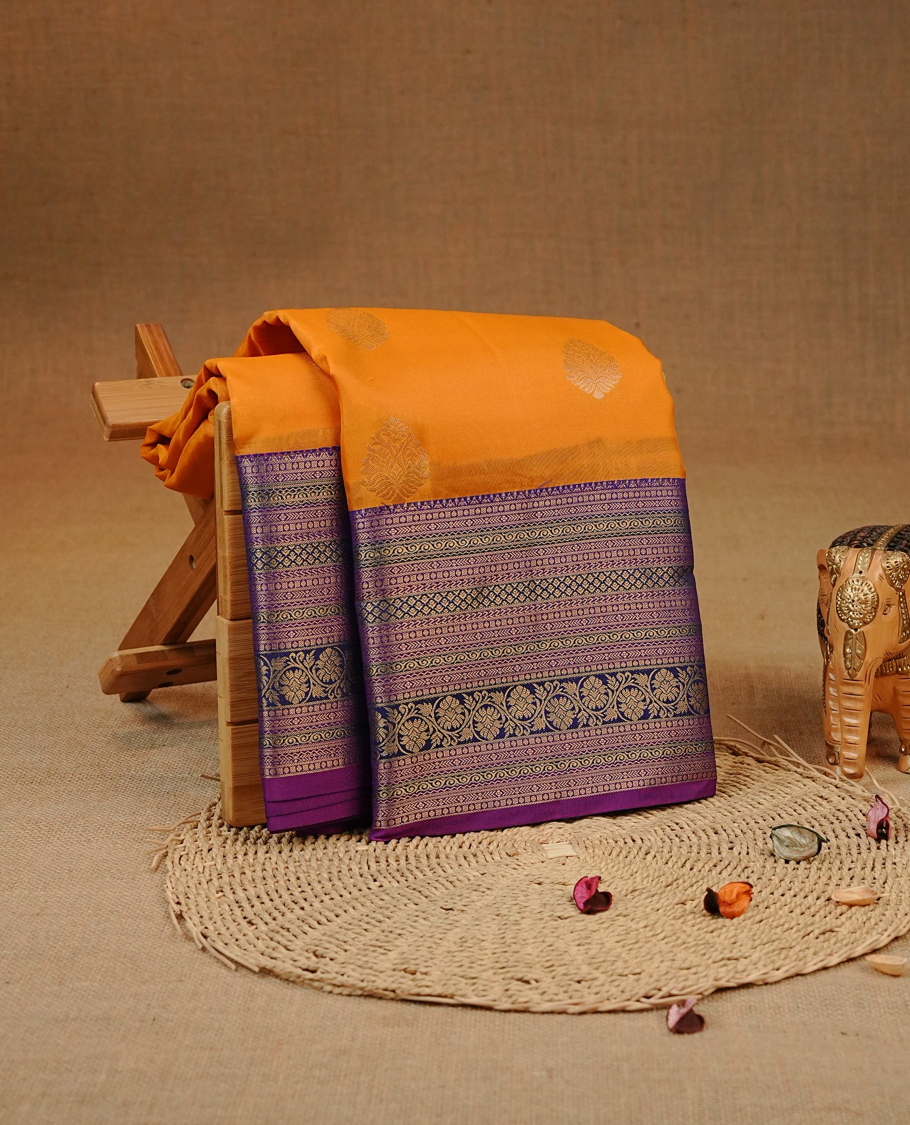 Orange colour Kancheepuram silk saree featuring Gold zari Motifs on body, complemented by Multicolour with Traditional border, comes with matching blouse piece.
