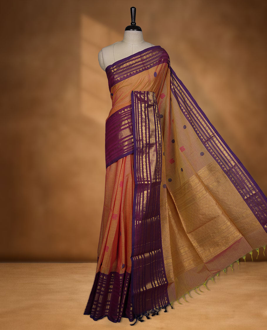 Dusty orange colour chettinad cotton saree featuring Purple colour motifs on body, contrast purple colour border with gold zari border, pallu and paired with matching blouse.