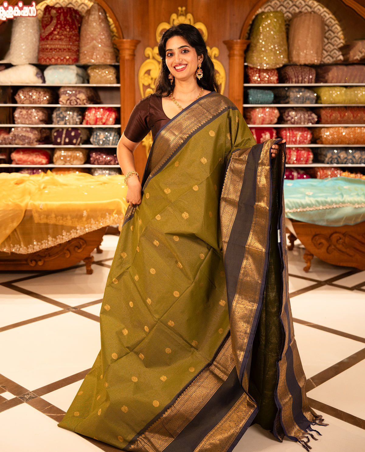 Olive with Blue colour Chettinad cotton saree featuring Gold zari strips with peacock motifs on body, complemented by contrast colour border with zari design & grand pallu, comes with matching blouse piece.