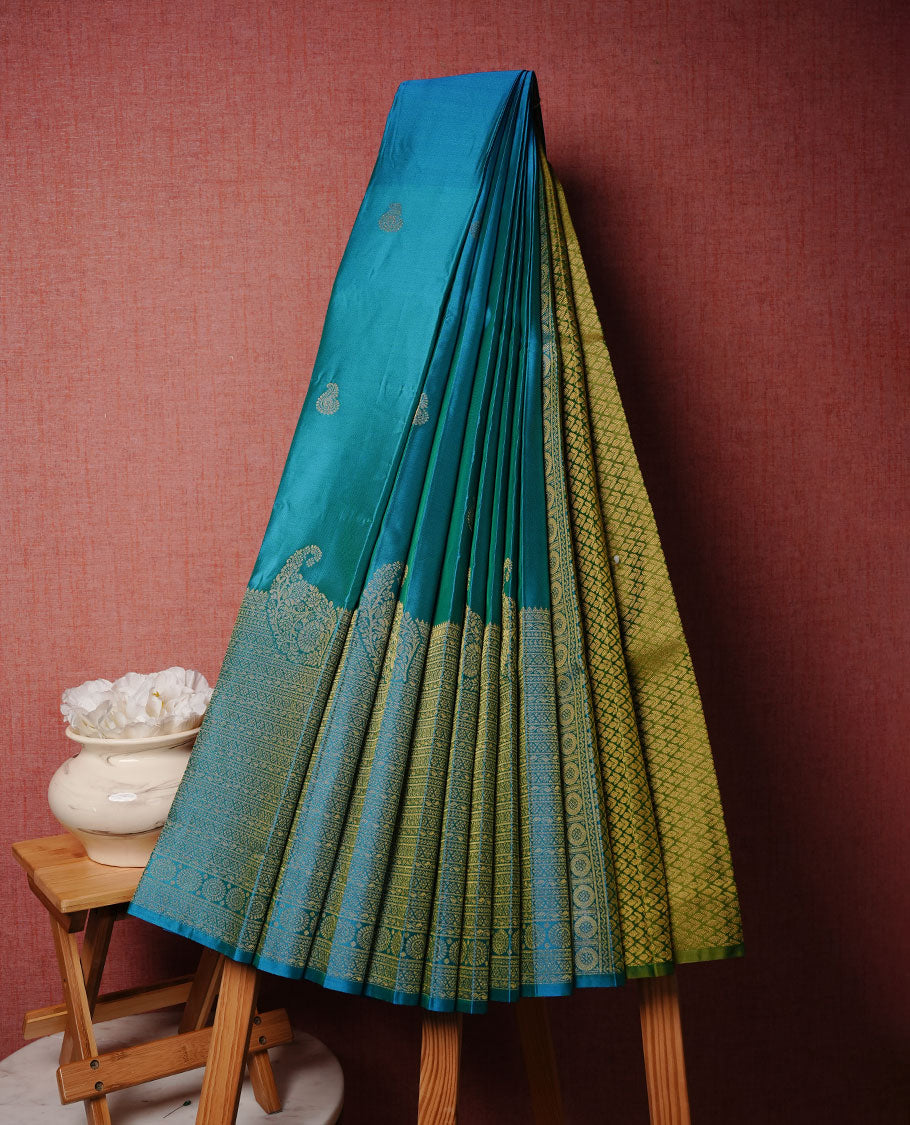 Olive & blue double shade colour soft silk saree featuring Gold zari motifs on body, complemented by self colour with traditional border, paired with matching contrast blouse piece.