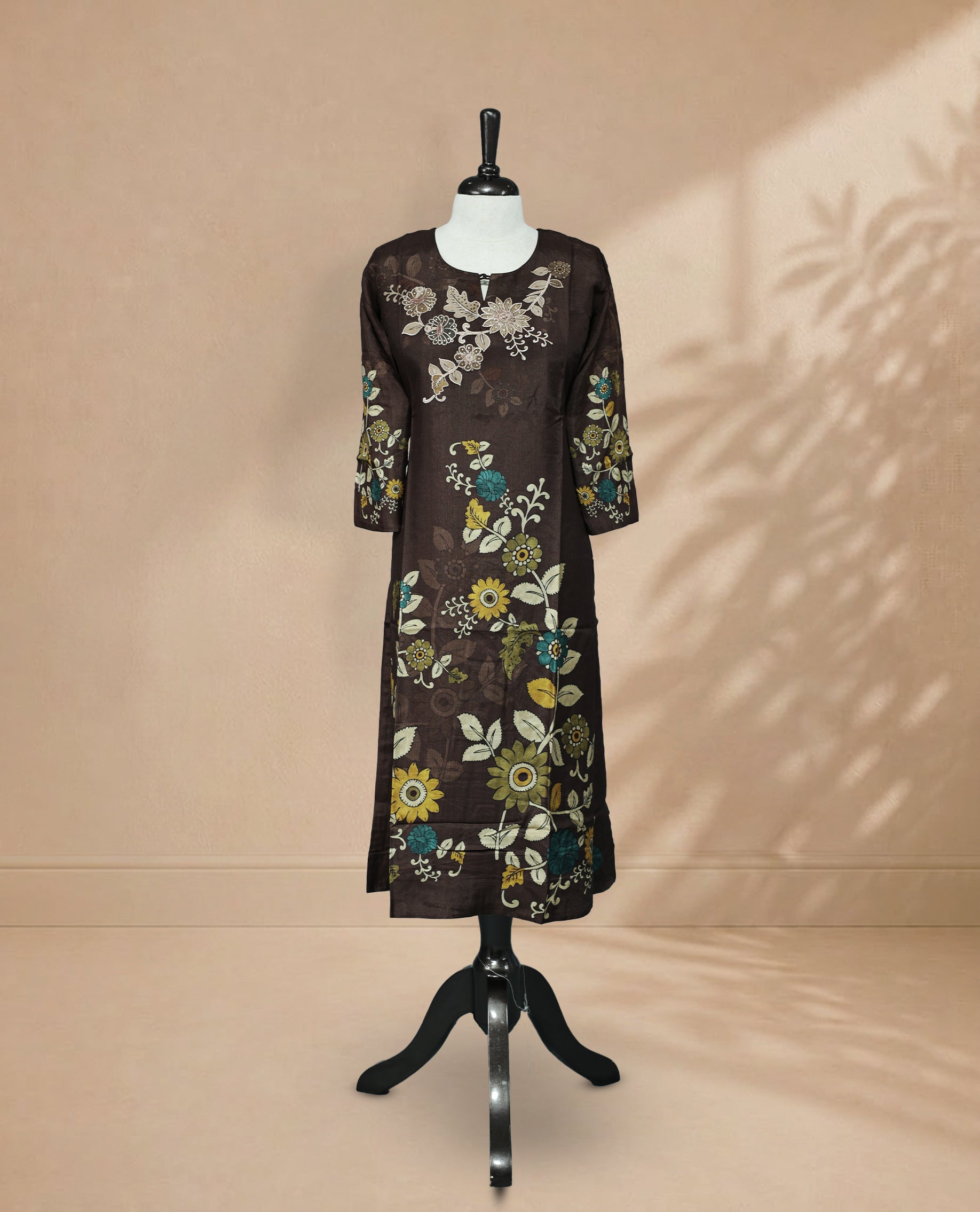 Brown Kurti featuring digital floral prints across the body, a U-shaped neckline adorned with stone and threadwork, and a 3/4-sleeve design.